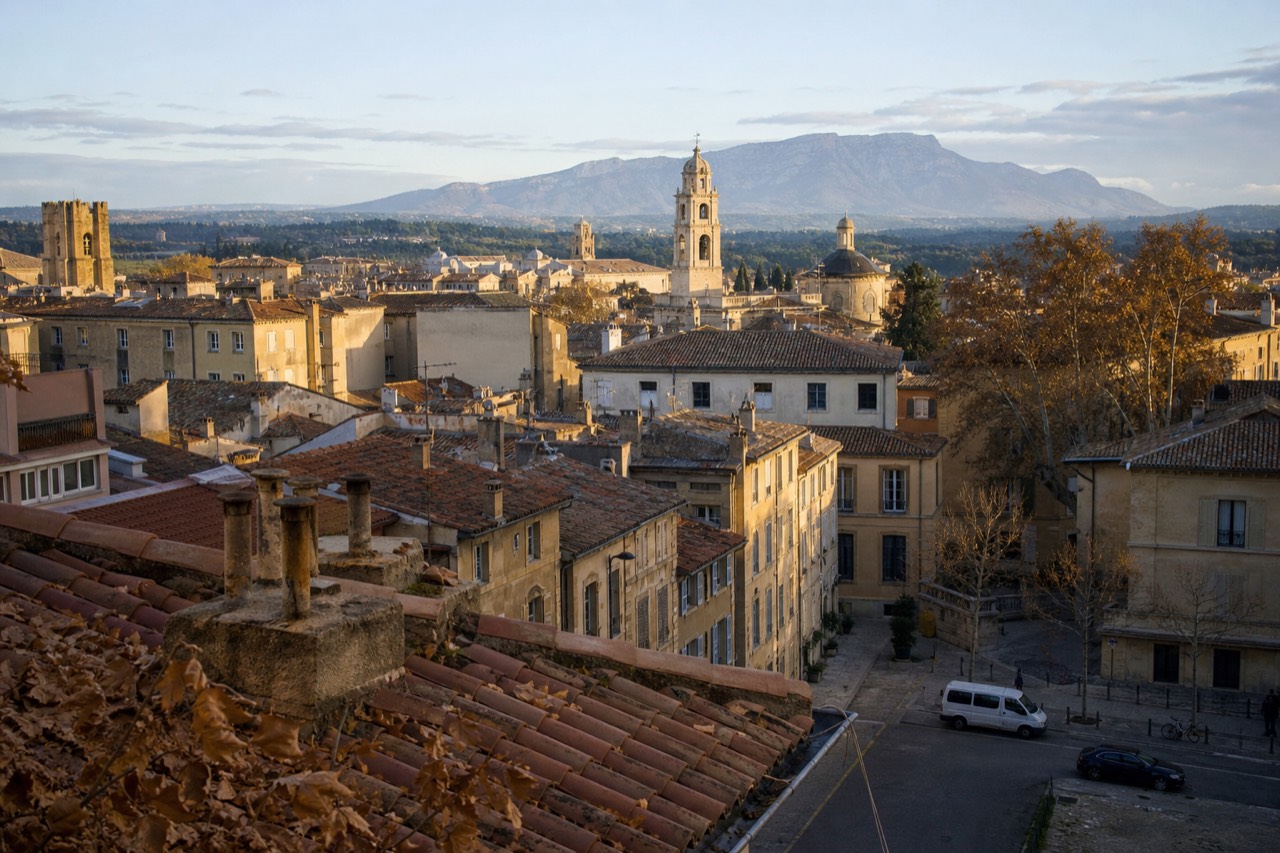 View over terracotta rooftops in Aix-en-Provence with the Sainte-Victoire mountain in the distance, no text, no logos, no people