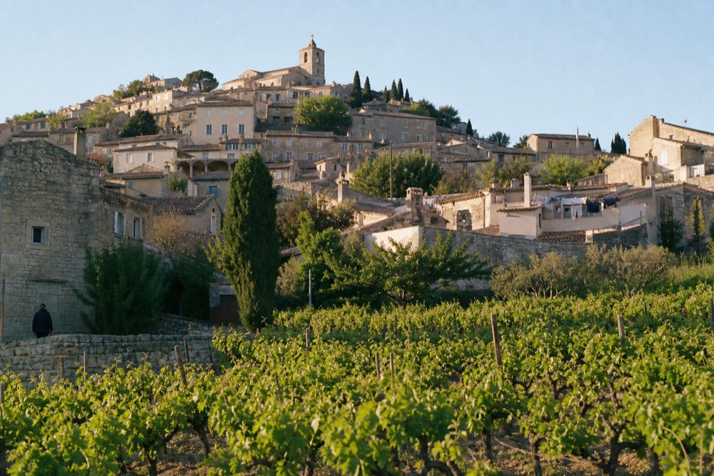 Stone hilltop village above vineyards in the Luberon, no text, no logos, no people