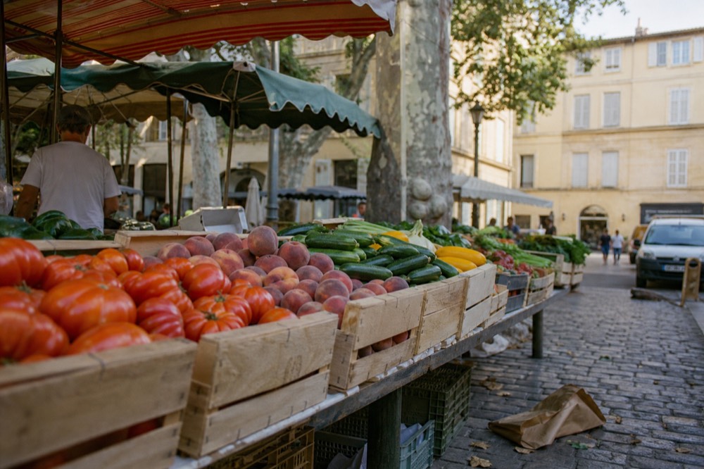 Fresh produce stalls at a morning market in Aix-en-Provence, no text, no logos, no people.