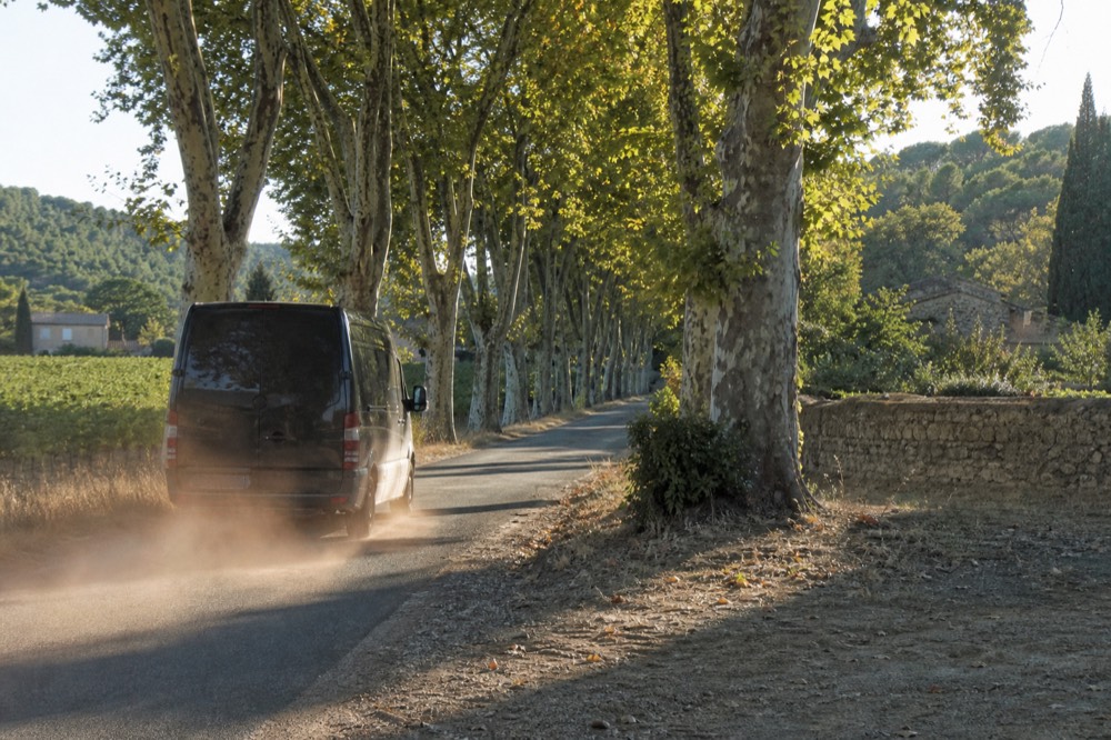 Wine tour van on a country road near Aix-en-Provence, no text, no logos, no people