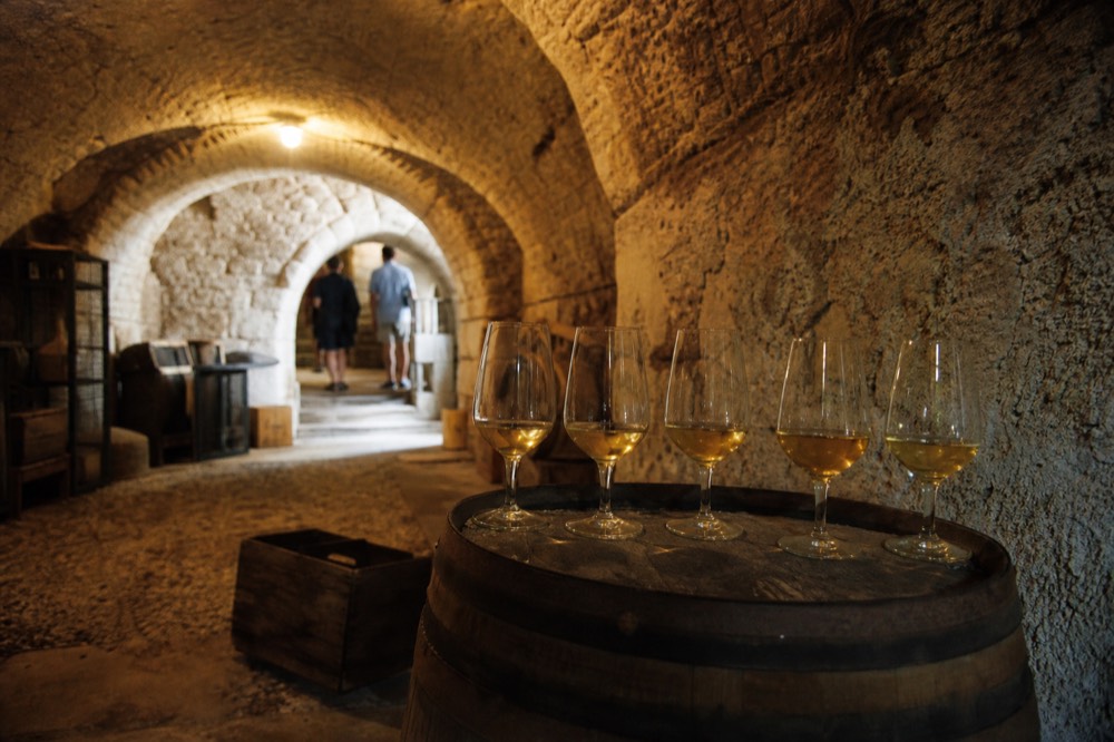 Small group of tasting glasses on a barrel in a Provençal cellar, no text, no logos, no people