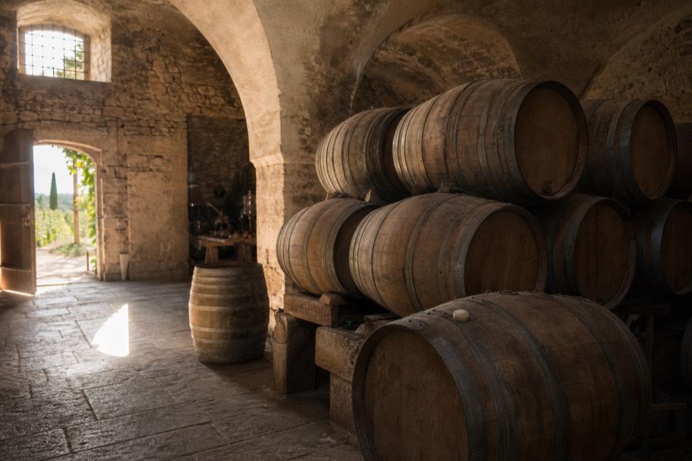 Wine barrels in a Luberon cellar with soft light, no text, no logos, no people